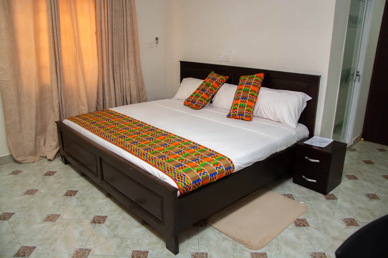 Guest room at Osdala Lodge with a king-size bed and colourful Ghanaian textile accents