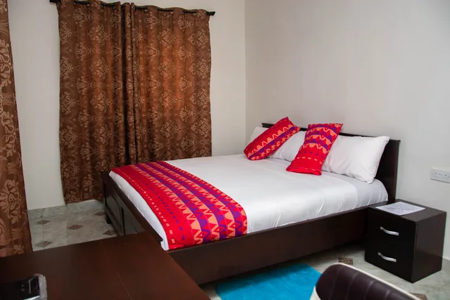 Guest bedroom with red Ghanaian textile accents